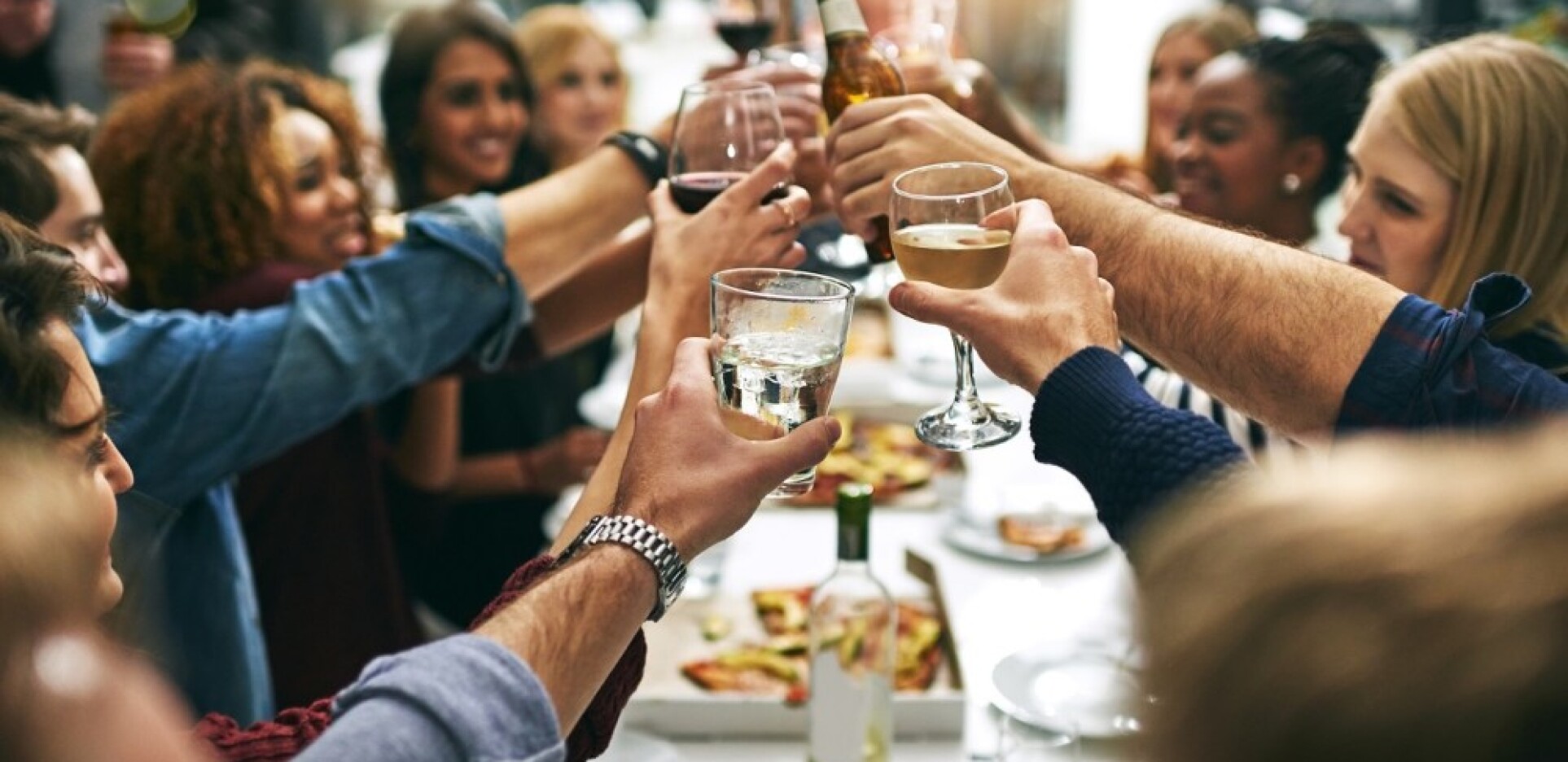 Guests raising glasses for a celebratory toast during a private event or banquet.