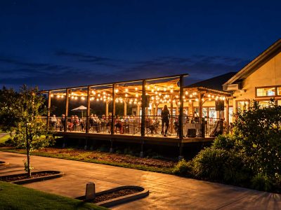 Outdoor event patio at Castle Oaks Golf Club illuminated by string lights during an evening gathering in Ione, CA.