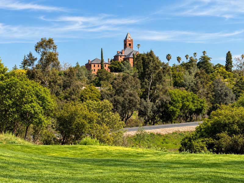Historic Preston Castle rising above the surrounding trees and rolling landscape in Ione, California.